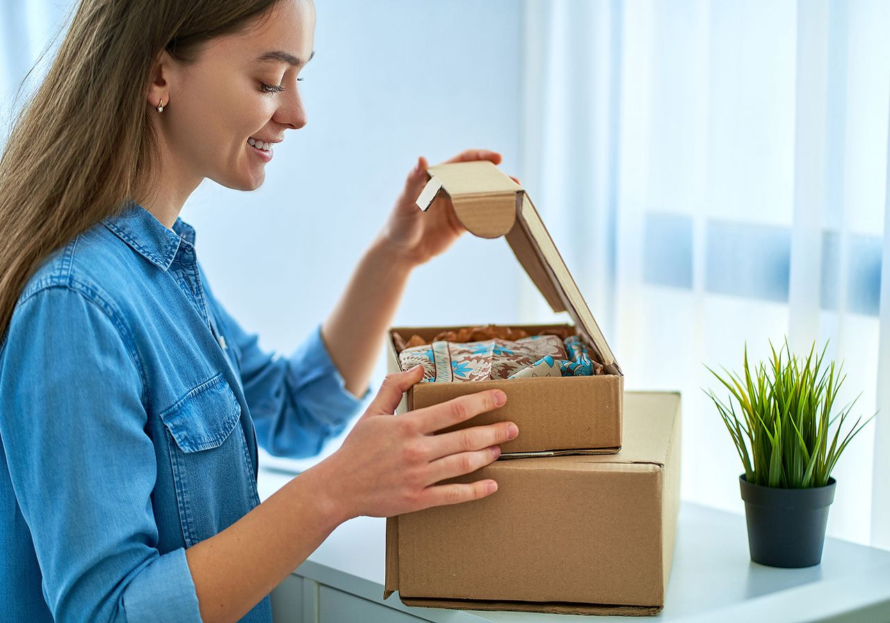 A woman is unpacking a delivery box.